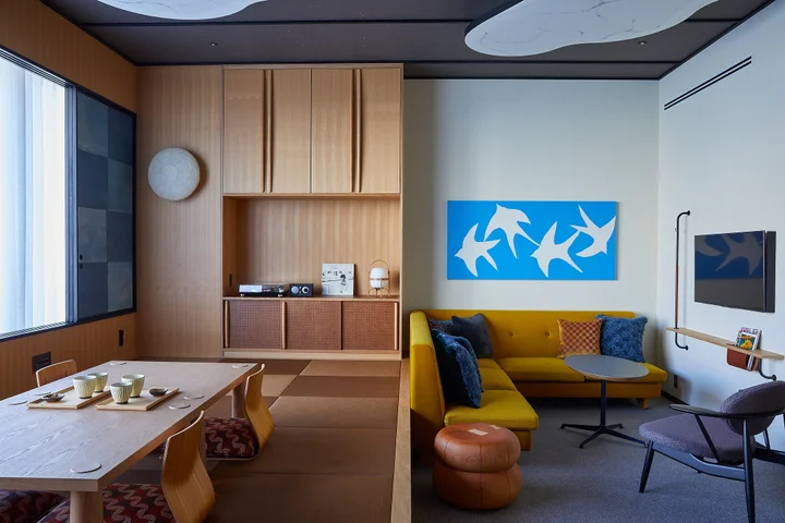 A guest room with a tatami dining platform, a yellow sofa and a low table.