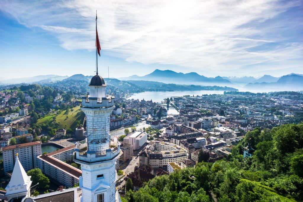 A white tower above Lucerne, with the lake and mountains beyond.