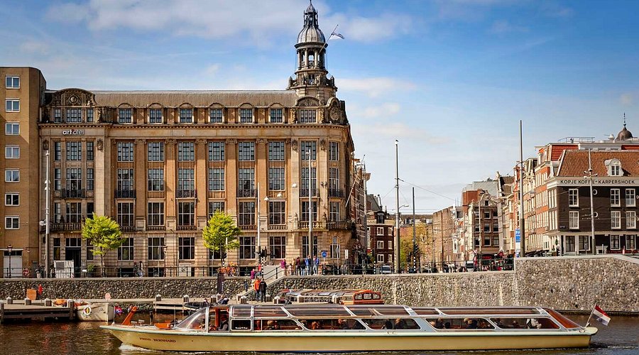 A canal-side hotel building with a corner turret, seen across the water.