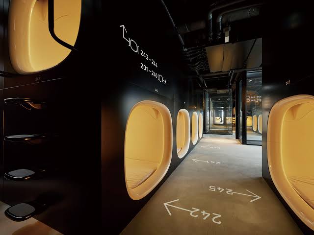 A dark corridor of stacked capsules with numbered floor markings.